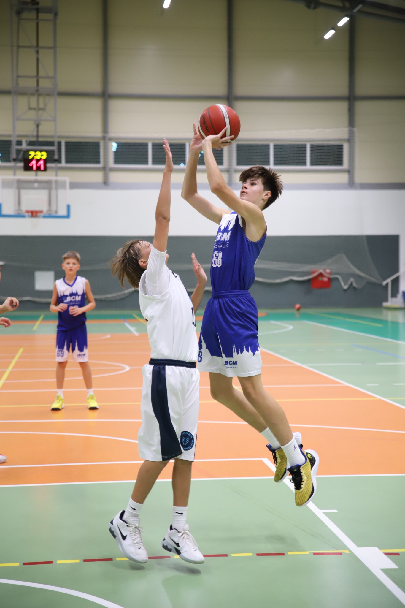 Hráč BCM Olomouc U13 zakončuje přes obránce